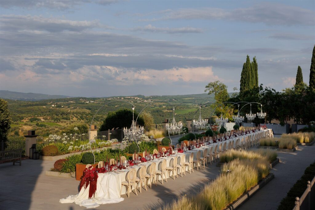 An Unforgettable Anniversary at Castello del Nero: A Three-Day Celebration in Tuscany 30 Elegant outdoor long table setting with chandeliers and Tuscan landscape