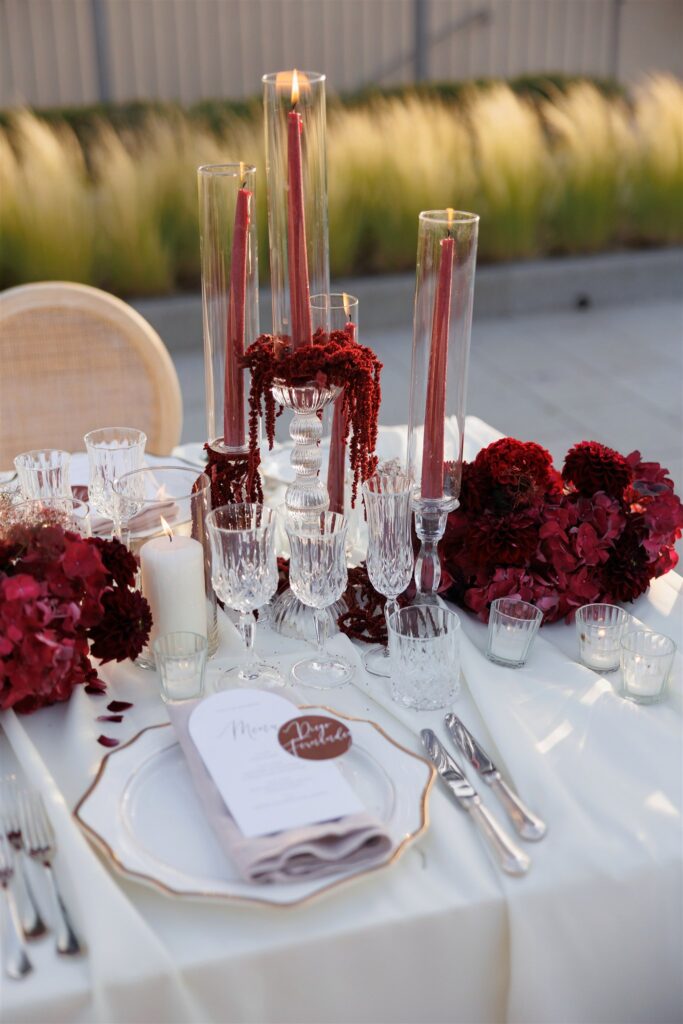 An Unforgettable Anniversary at Castello del Nero: A Three-Day Celebration in Tuscany 33 Elegant wedding reception table setting with red floral arrangements and tall candles. Anniversary Castello del Nero - Italian Wedding Designer