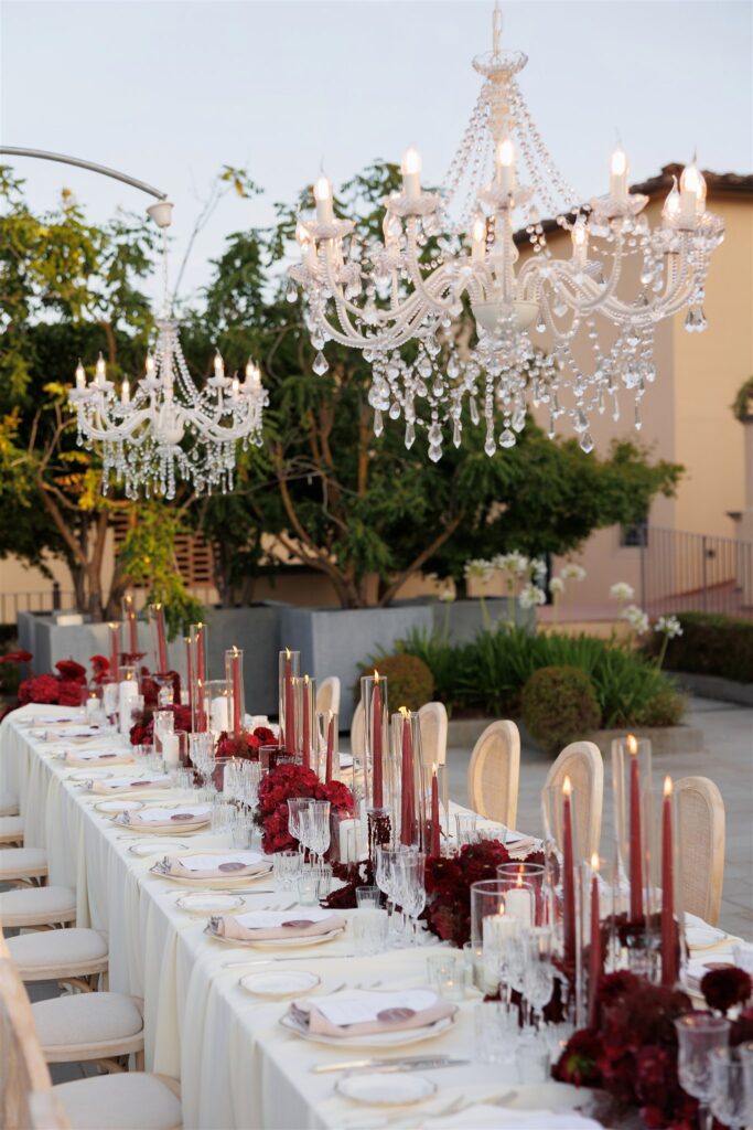 An Unforgettable Anniversary at Castello del Nero: A Three-Day Celebration in Tuscany 38 Elegant outdoor long table setting with crystal chandeliers and red floral centerpieces. Anniversary Castello del Nero - Italian Wedding Designer