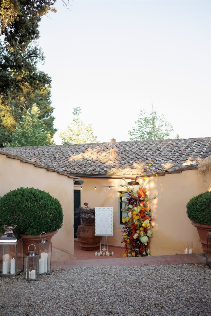 An Unforgettable Anniversary at Castello del Nero: A Three-Day Celebration in Tuscany 10 Outdoor wedding seating chart with floral arrangement and lanterns. Anniversary Castello del Nero - Italian Wedding Designer