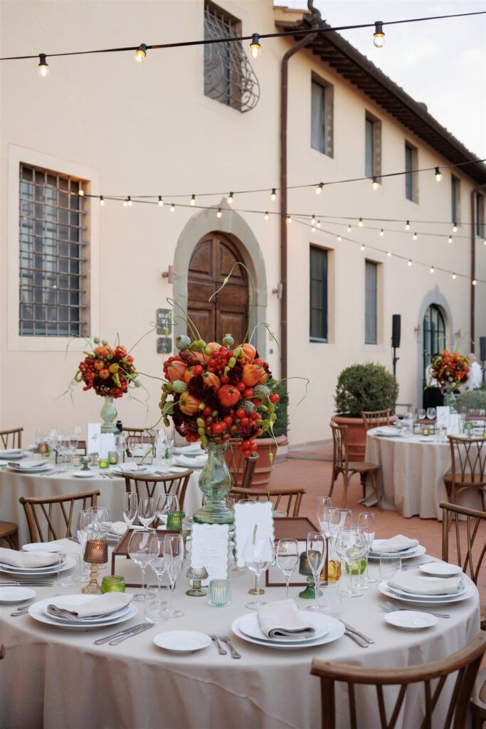 An Unforgettable Anniversary at Castello del Nero: A Three-Day Celebration in Tuscany 11 Outdoor wedding reception tables with floral centerpieces and string lights. Anniversary at Castello del Nero - Italian Wedding Designer