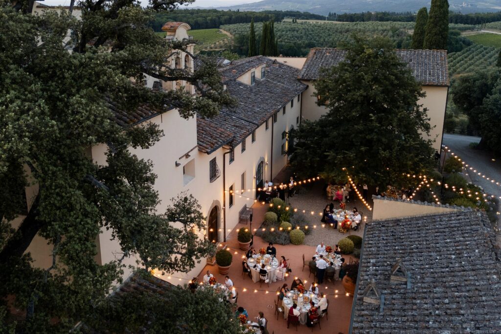 An Unforgettable Anniversary at Castello del Nero: A Three-Day Celebration in Tuscany 18 Tuscan villa courtyard with outdoor wedding reception and string lights. Anniversary Castello del Nero - Italian Wedding Designer