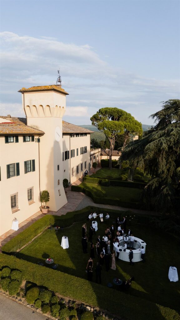 An Unforgettable Anniversary at Castello del Nero: A Three-Day Celebration in Tuscany 24 Guests mingling at an outdoor wedding reception at a Tuscan villa. Anniversary Castello del Nero - Italian Wedding Designer