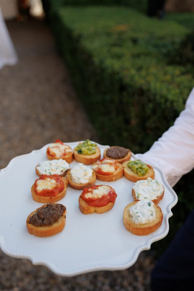 An Unforgettable Anniversary at Castello del Nero: A Three-Day Celebration in Tuscany 7 White platter of assorted gourmet appetizers, including bruschetta and dips. Anniversary Castello del Nero - Italian Wedding Designer